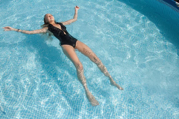 Foto de moda de menina bonita sexy com cabelo morena em biquíni elegante toma um banho de sol na piscina — Fotografia de Stock