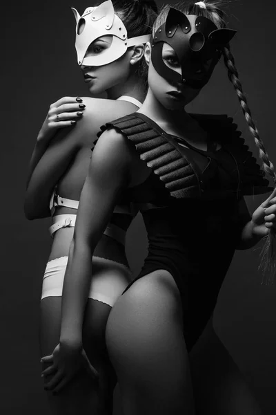 Dos chicas sexy en máscaras y cinturón de cuero (foto en blanco y negro ) —  Fotos de Stock