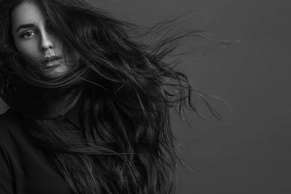 Retrato de uma jovem menina bonita com cabelo de luxo voando (foto em preto e branco ) — Fotografia de Stock