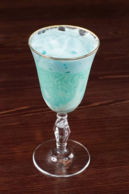 Ahşap arka planda dondurmalı mavi kokteyl.