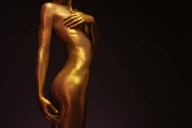 Altın kaplamalı seksi kız poz veriyor.