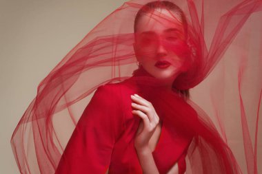 Kırmızı peçeli bir mankenin modaya uygun portresi.