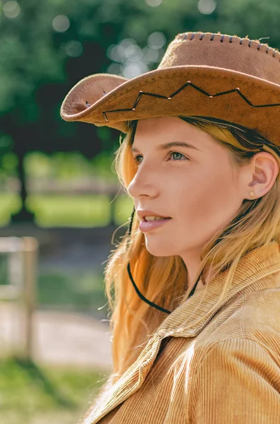 Uma rapariga de chapéu de cowboy a olhar directamente para a câmara. Mulher sexy com chapéu de cowboy . — Fotografia de Stock