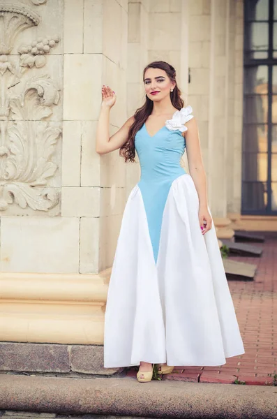 Muito sensual menina noiva pensativa com cabelo loiro longo em vestido de noiva branco em pé ao ar livre no fundo, imagem vertical — Fotografia de Stock