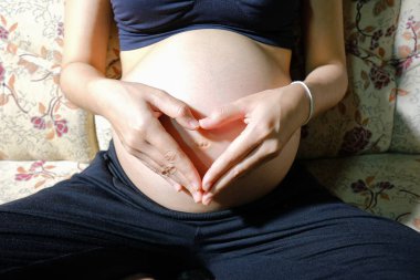 Karnını tutan hamile kadın.