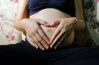 Karnını tutan hamile kadın.