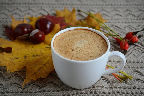 Cup of coffee with leaves and chestnuts — Stock Photo, Image