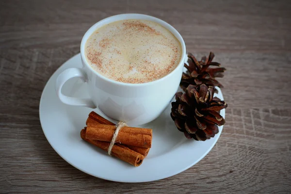 Cup of coffee and brown pine cone — Stock Photo, Image