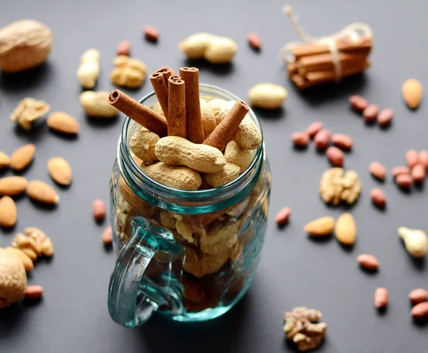 Assorted mixed nuts in a glass jar, peanuts, almonds, walnuts and sesame seeds