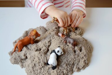 Kız bebek Kinetik kum ile oynamak