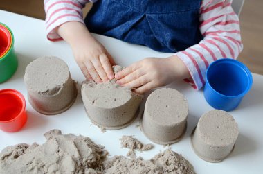 Kız bebek Kinetik kum ile oynamak