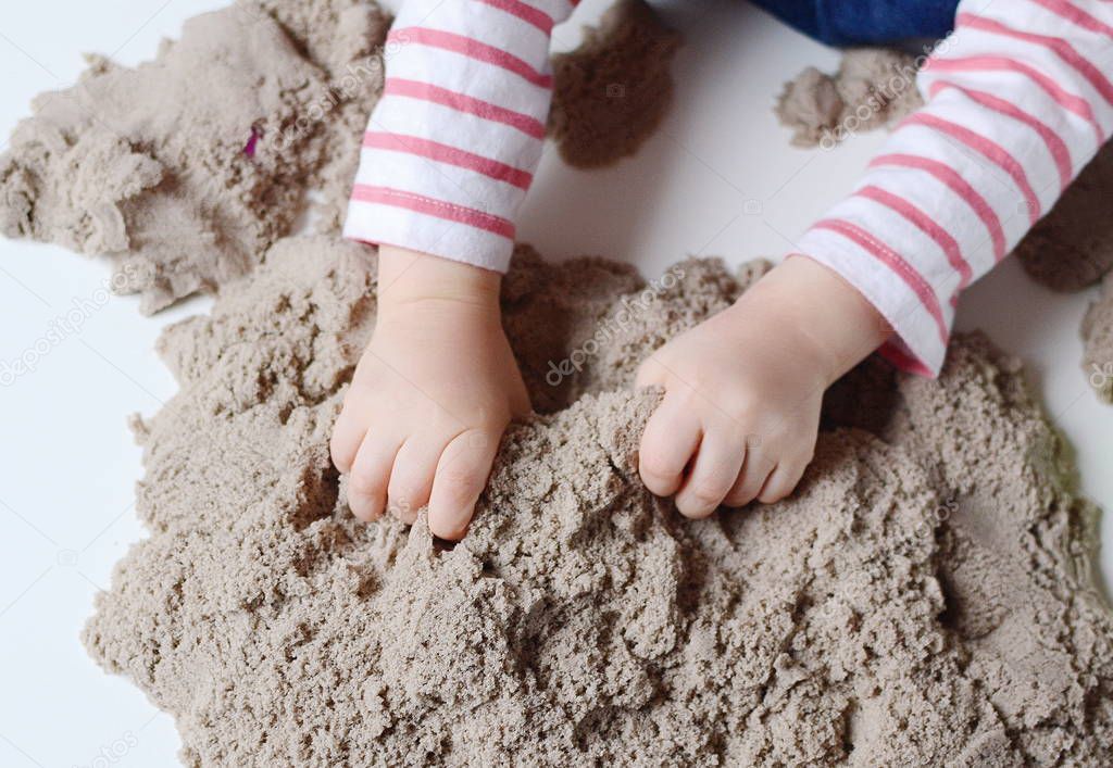 Baby girl play with kinetic sand