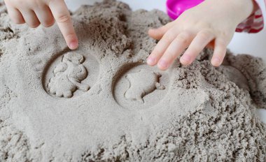 Kinetik kumla oynayan küçük kız