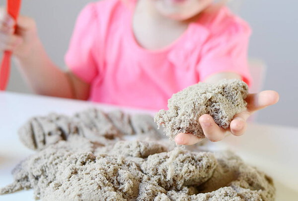 Little girl playing with kinetic sand