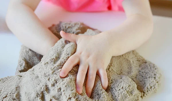 Meisje speelt met kinetisch zand — Stockfoto