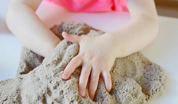 Little girl playing with kinetic sand