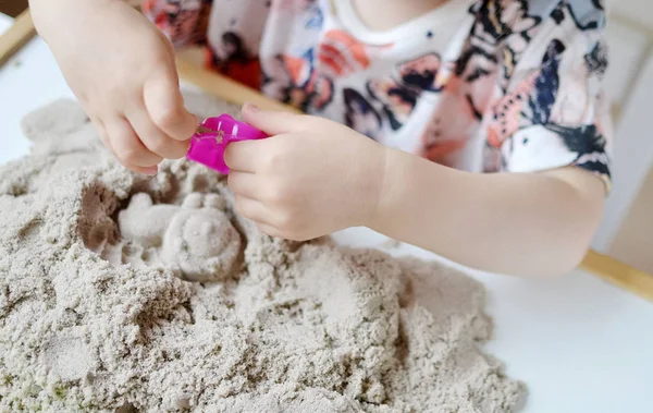 Meisje speelt met kinetisch zand — Stockfoto