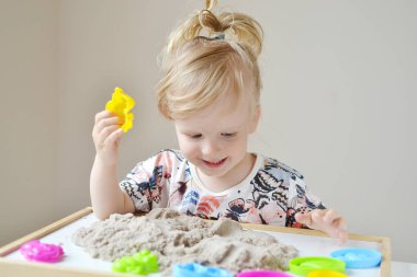 Kinetik kumla oynayan kız 