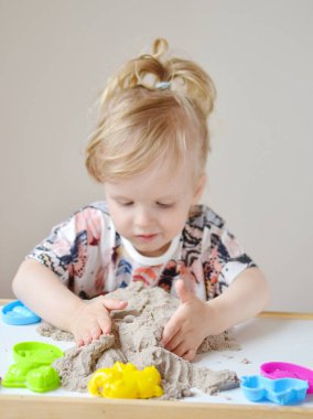 Kinetik kumla oynayan kız 