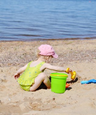 Little girl playing at the beach clipart