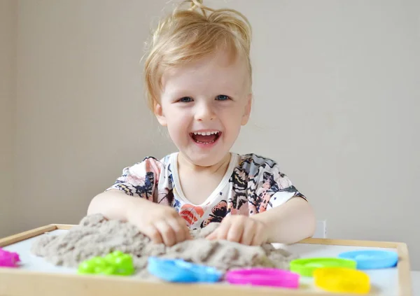 Meisje speelt met kinetisch zand — Stockfoto