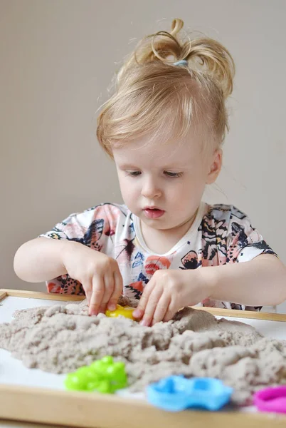 Meisje speelt met kinetisch zand — Stockfoto