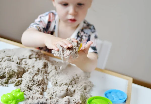 Meisje speelt met kinetisch zand — Stockfoto