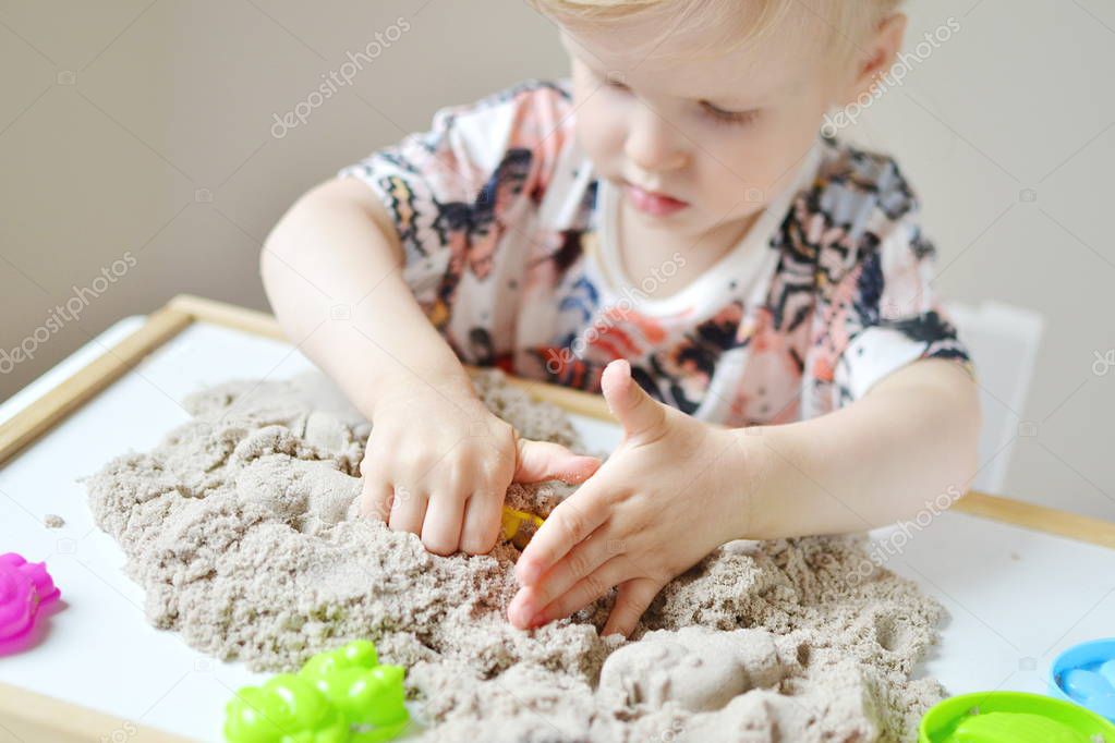 Girl playing with kinetic sand 