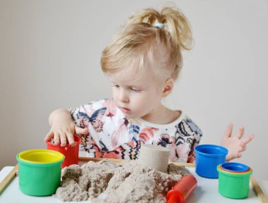 Küçük kız, eve erken eğitim Kinetik kumla oynayan 