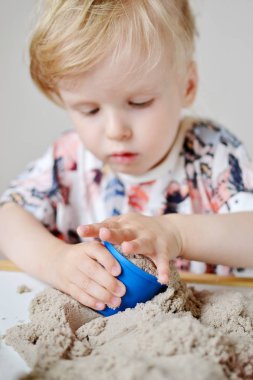 Küçük kız, eve erken eğitim Kinetik kumla oynayan 