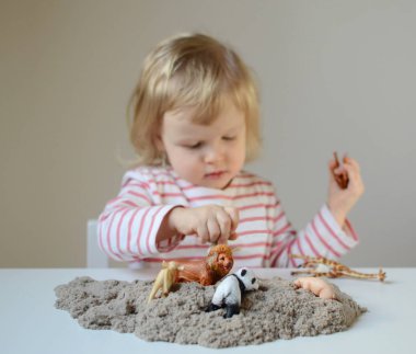 Küçük kız, eve erken eğitim Kinetik kumla oynayan 