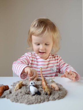 Küçük kız, eve erken eğitim Kinetik kumla oynayan 