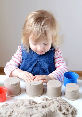 Küçük kız, eve erken eğitim Kinetik kumla oynayan 