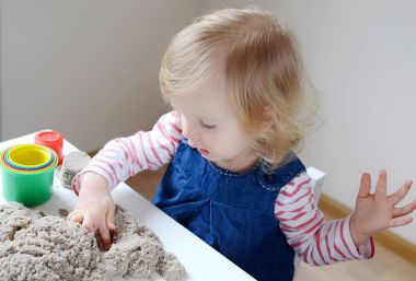 Küçük kız, eve erken eğitim Kinetik kumla oynayan 