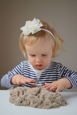 Küçük kız, eve erken eğitim Kinetik kumla oynayan 
