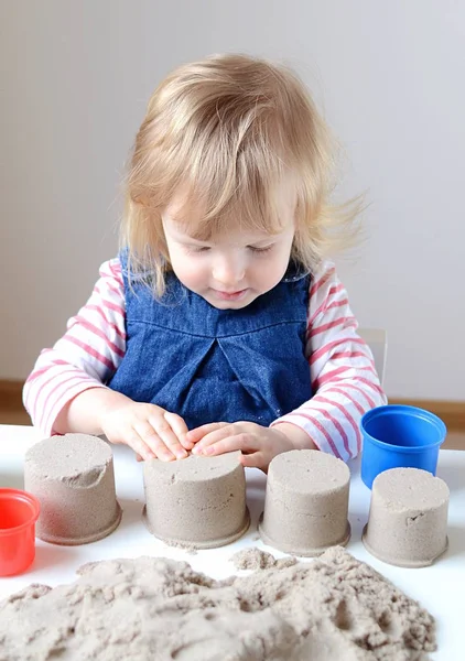 Küçük kız, eve erken eğitim Kinetik kumla oynayan 