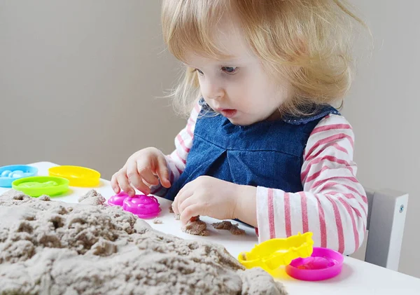Küçük kız, eve erken eğitim Kinetik kumla oynayan 