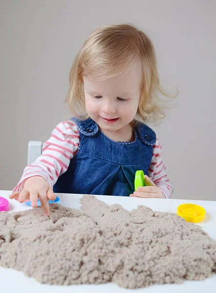 Küçük kız, eve erken eğitim Kinetik kumla oynayan 