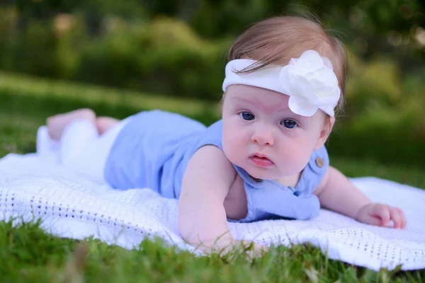 Babymeisje liggend in het gras — Stockfoto