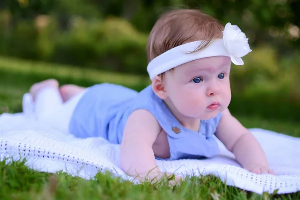 Petite fille bébé couché dans l'herbe verte — Photo