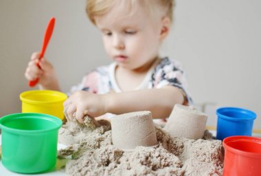 Küçük kız evde Kinetik kumla oynayan 