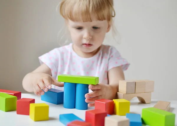 Caucasien fille jouer avec en bois coloré cubes à la maison — Photo