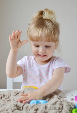 Küçük kız evde Kinetik kumla oynayan 