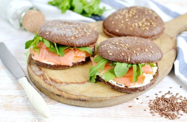 Somon Sandviç krem taze ve roka kesme tahtası üzerinde füme