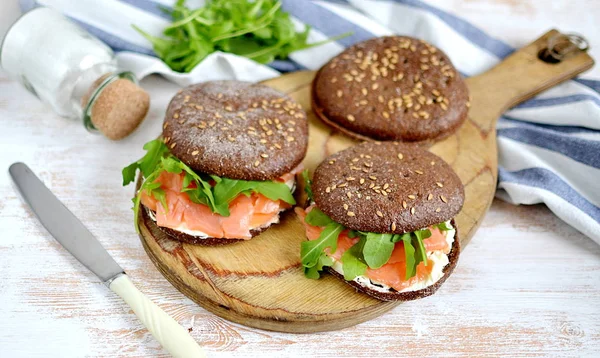 Somon Sandviç krem taze ve roka kesme tahtası üzerinde füme