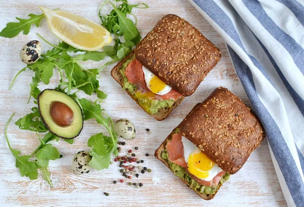 Smoked Salmon Sandwich with Avocado and Quail Egg Food Healthy Breakfast Wooden Background