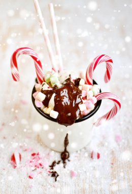 Bardak sıcak çikolata, şekerleme, şeker kamışı kar üzerinde