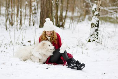 Güzel genç kadın ile onun köpek beyaz Samoyed mevsimlik karlı kış Forest Park yürüme 