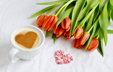 Kapuçino tarçın ve çiçek kompozisyon Lale beyaz arka plan Sevgililer günü bahar kavramı kalp desenli