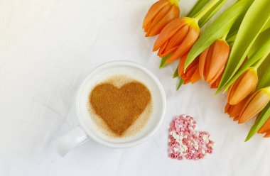 Kapuçino tarçın ve çiçek kompozisyon Lale beyaz arka plan Sevgililer günü bahar kavramı kalp desenli